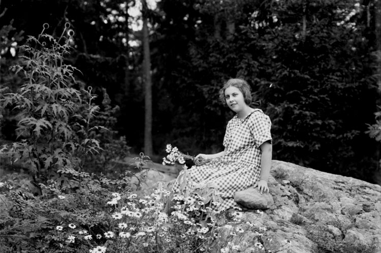 En flicka sittande på en sten.
Margit Lindskog