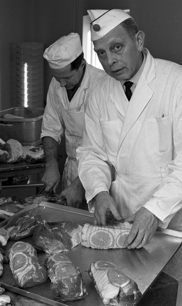 Från gris till skinka. Slakthuset 11 februari 1965.

Två män arbetar med livsmedelstillverkning.
Närmast på bilden är Evert Wing.