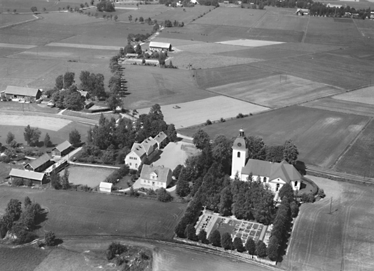 Flygfoto över Rinkaby kyrka, bostadshus, skola.
Bilden tagen för vykort.