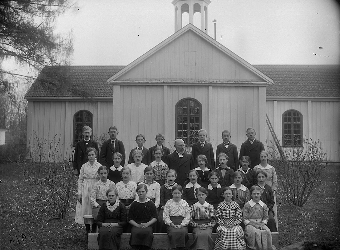 Konfirmation (?), barn och en präst. Kyrkobyggnad i bakgrunden.