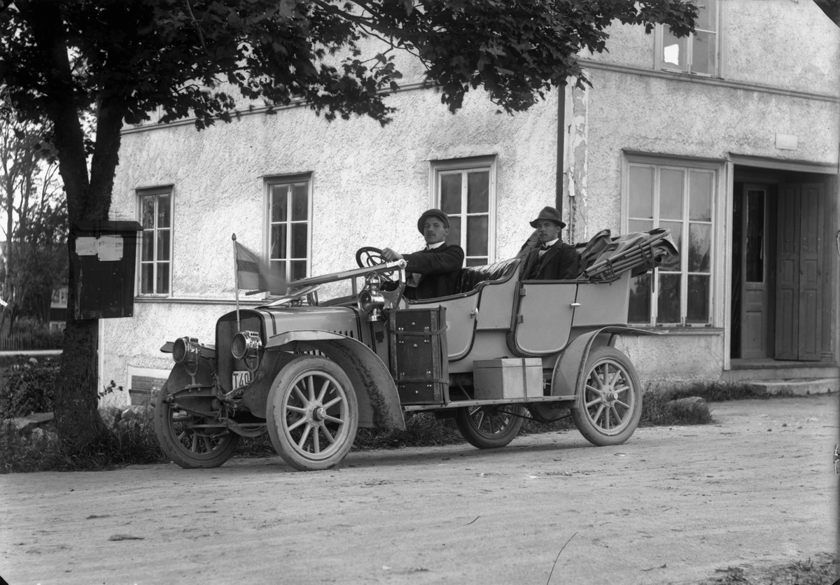 Två män i en bil, vid Nya Norra Hyddan, Svennevad. 
Bilen på bilden är en tysk Piccolo från början av 1910-talet. Personerna i bilen är fotografen Gustaf Ferdinand Hallbergs söner, Aron och Anton.