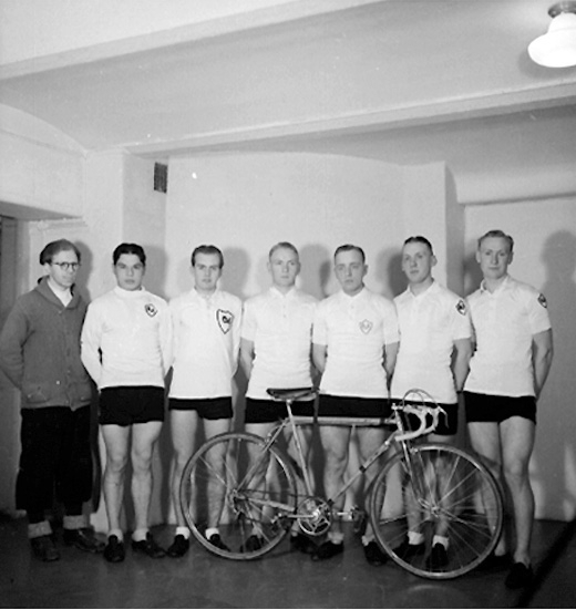Grupp sju män och en cykel.