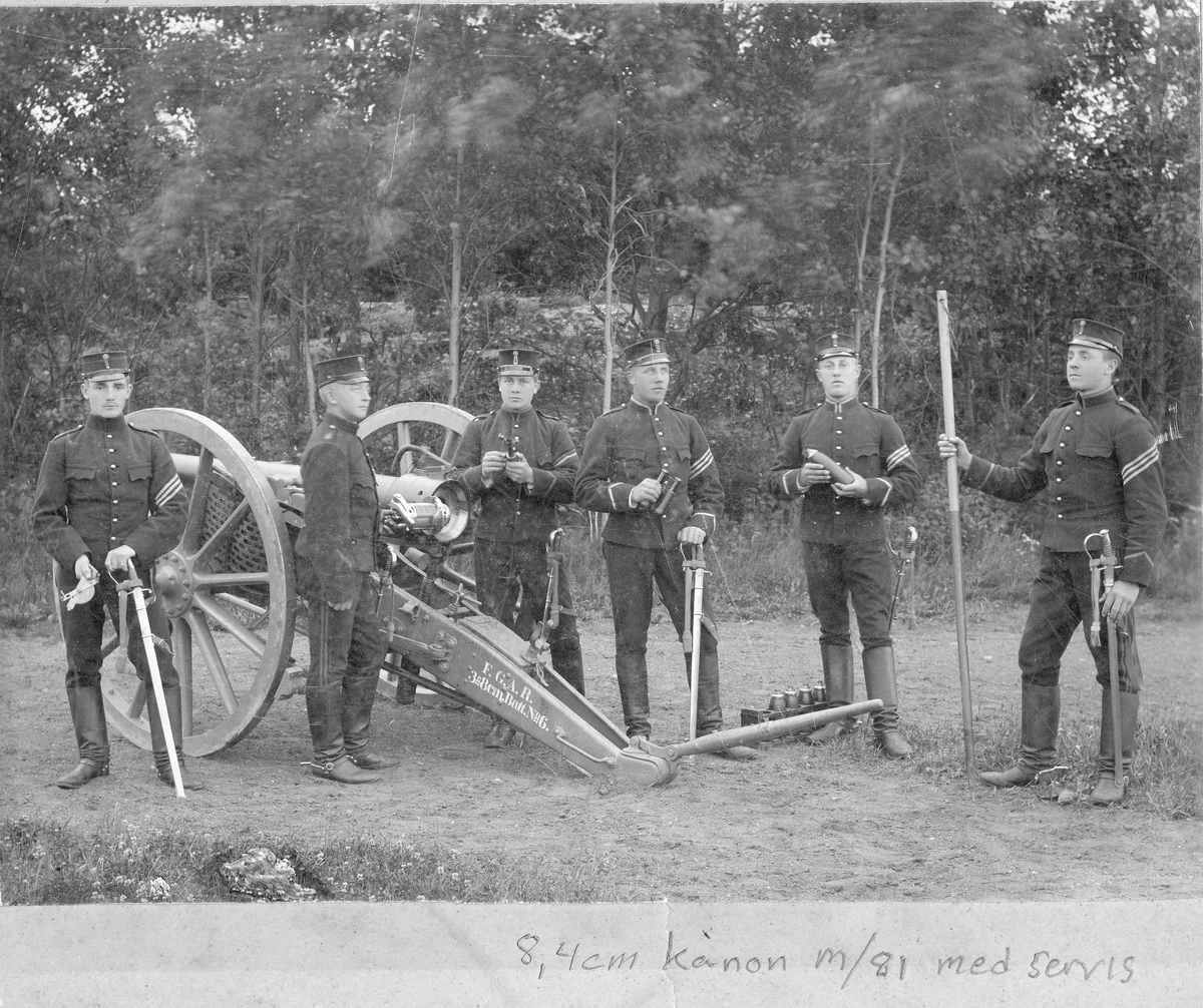 Artillerister ur Andra Svea artilleriregemente A 5 upställda brevid en 8,4 cm kanon m/1881 med servis. Soldaterna är iförda uniform och bär sabel m/1889.