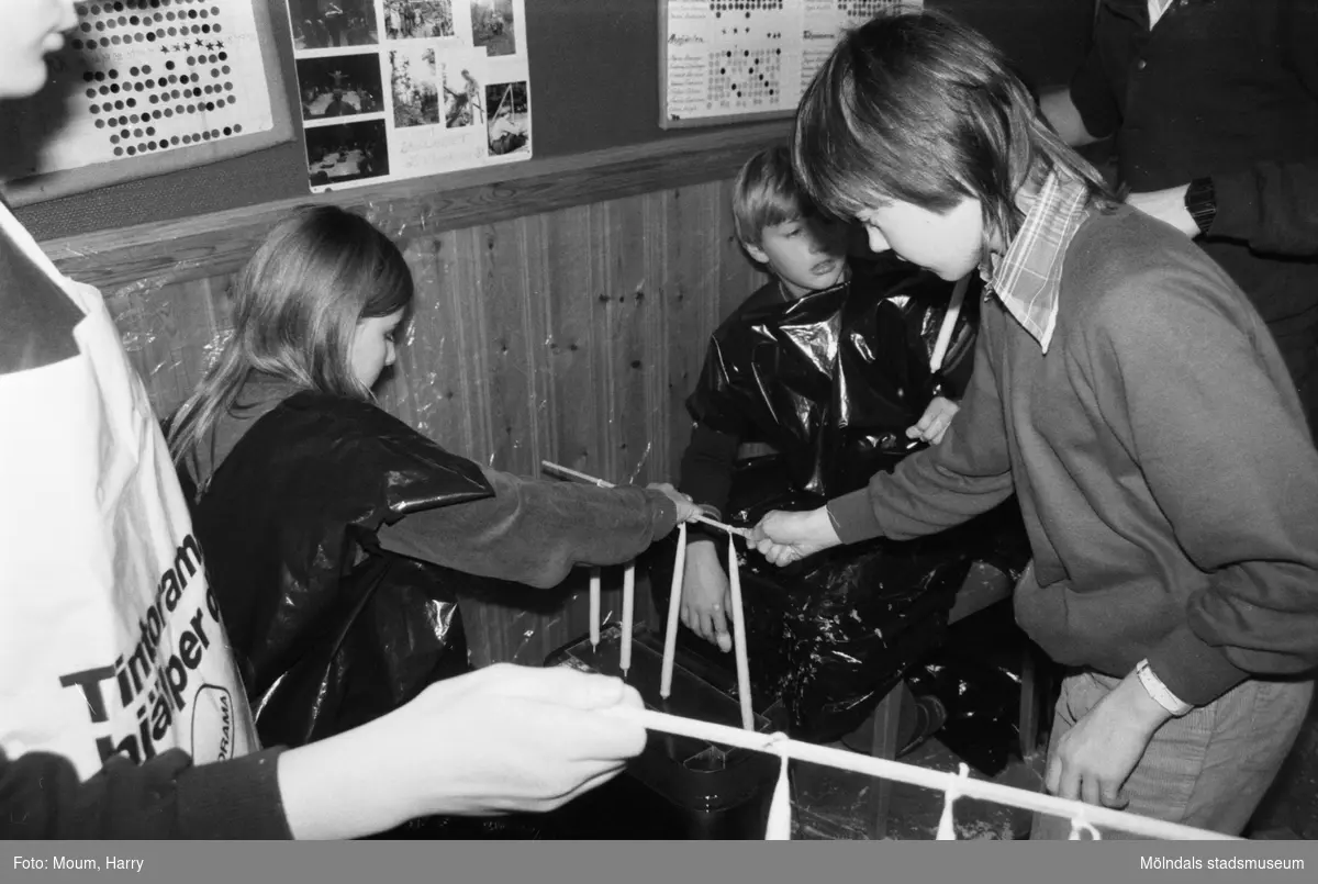 Ungdomar från Annestorpdalens scoutkår stöper ljus i scoutgården på Konditorivägen 3 i Lindome, år 1983.

För mer information om bilden se under tilläggsinformation.