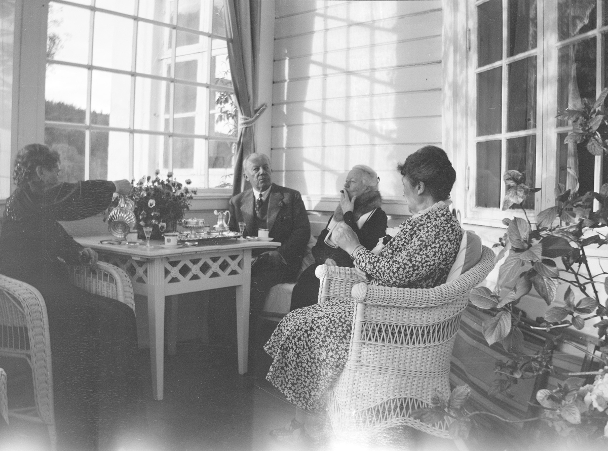Christian Pierre Mathiesen og tre damer sitter på glassverandaen på Linderud Gård.
