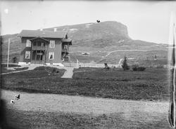 Et toetasjes hus med inngjerdet hage. Huset er bygget i et f