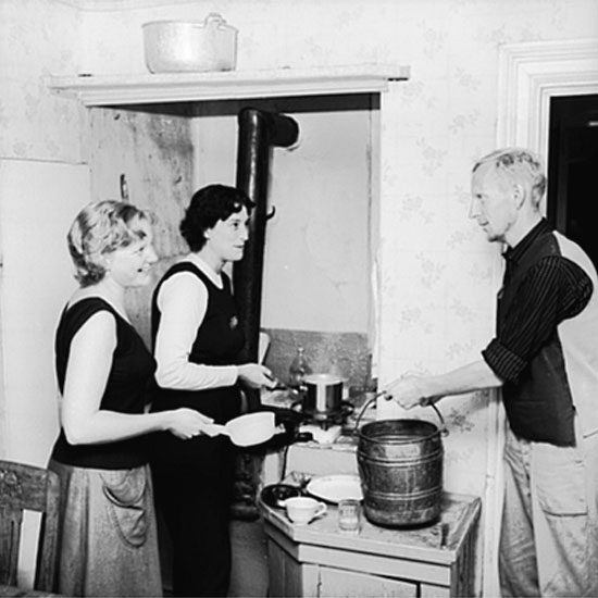 Skådespelarna hemma hos Helmer Linderholm.
Två kvinnor och en man i köket.