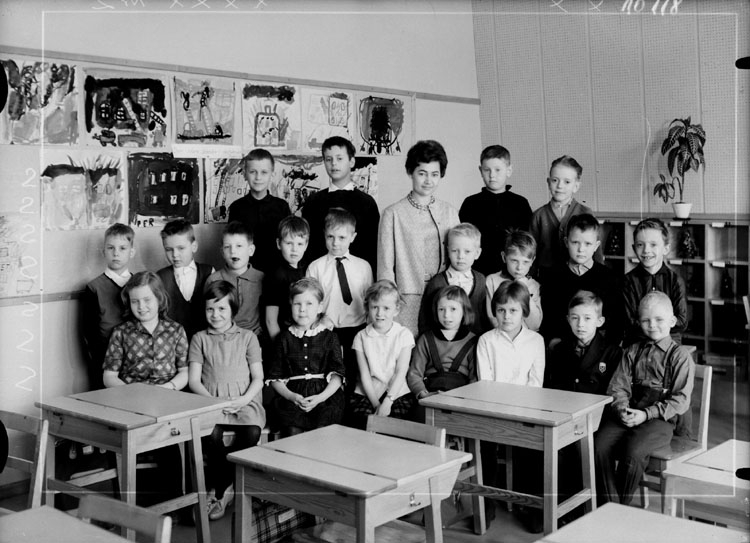 Vasaskolan, klassrumsinteriör, 21 skolbarn med lärarinna fröken  Astrid Lindlöf.
Klass 1v, sal 5.