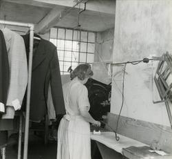 Kvinne stryk klede i presseriet ved Wilhelm Kahrs Kemisk Ren