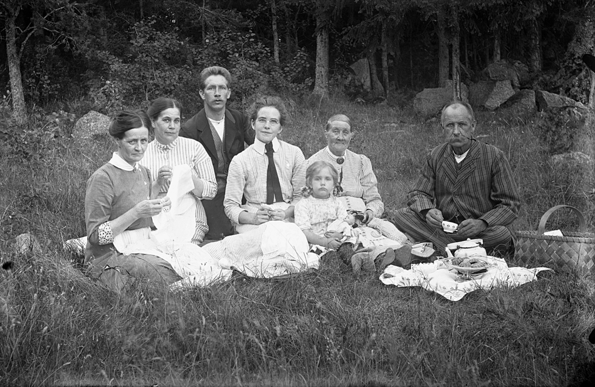 Familjegrupp sju personer i gräset.
Johannes Natanael Bäckman och Edit Bäckman (med slips).