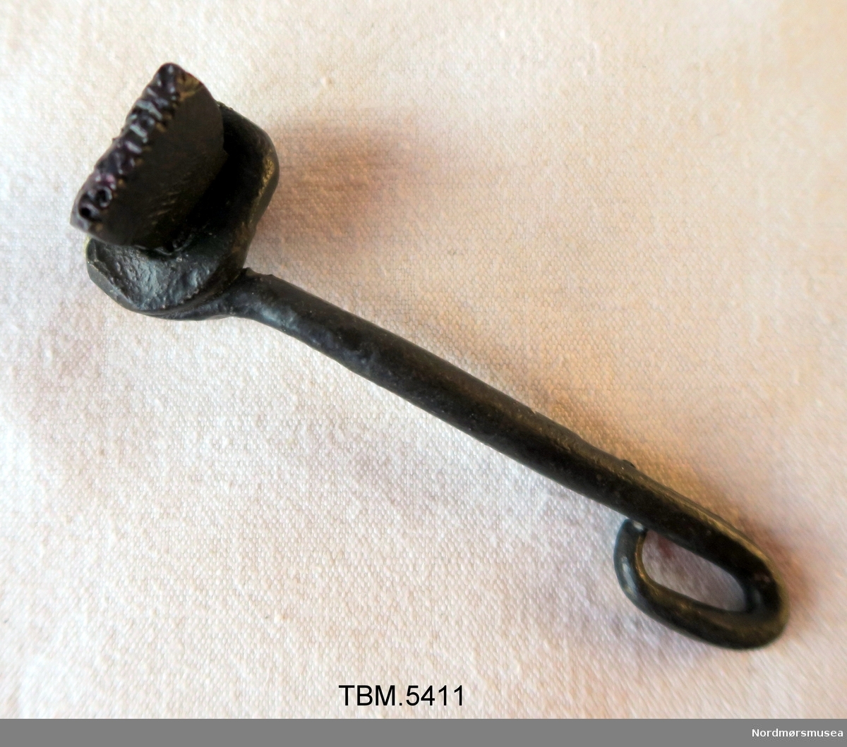 Eit jernstykke med namnet SKårstein. Handtak av jern. Namnet kan bankast inn i verktøy som smeden laga.