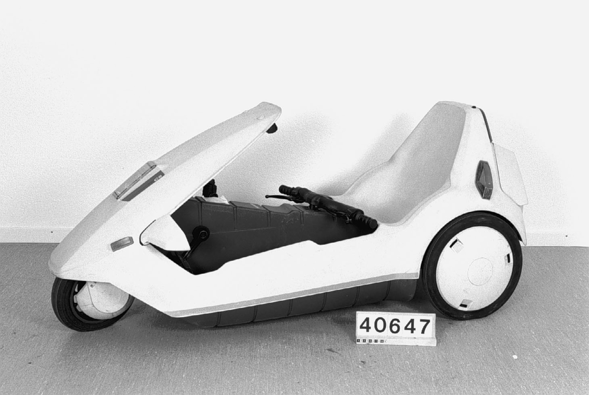 En trehjulig elektrisk moped konstruerad av Clive Sinclair. Hoover tvättmaskinsmotor driver bakhjulen. Batteri av typ mc- startbatteri. Kaross av gråvit plast.  Motor 12 volt, 259 Watt, 3300 varv per minut Körsträcka 2-3 mil.