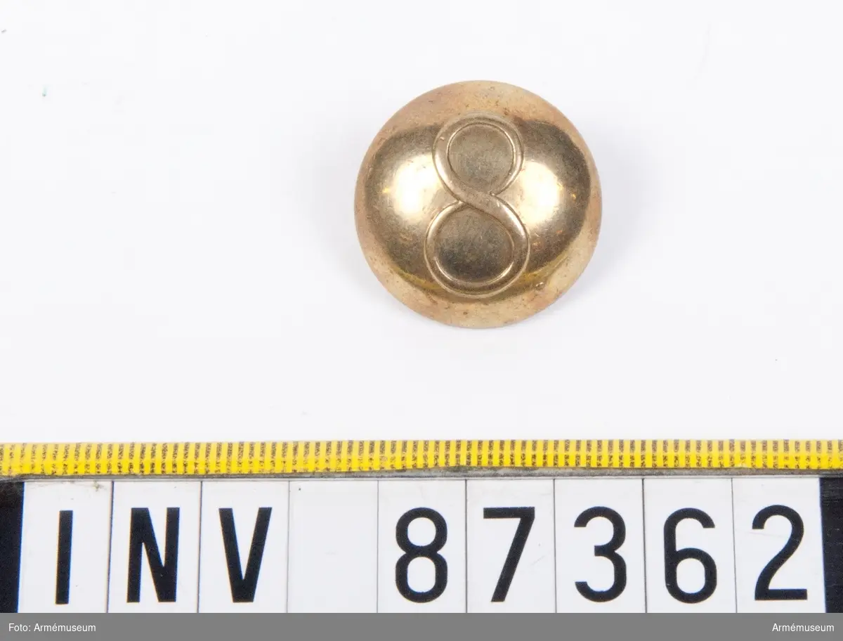Grupp C.
En knapp med siffran 8.
Tillverkad av L. W. Boström, Stockholm.