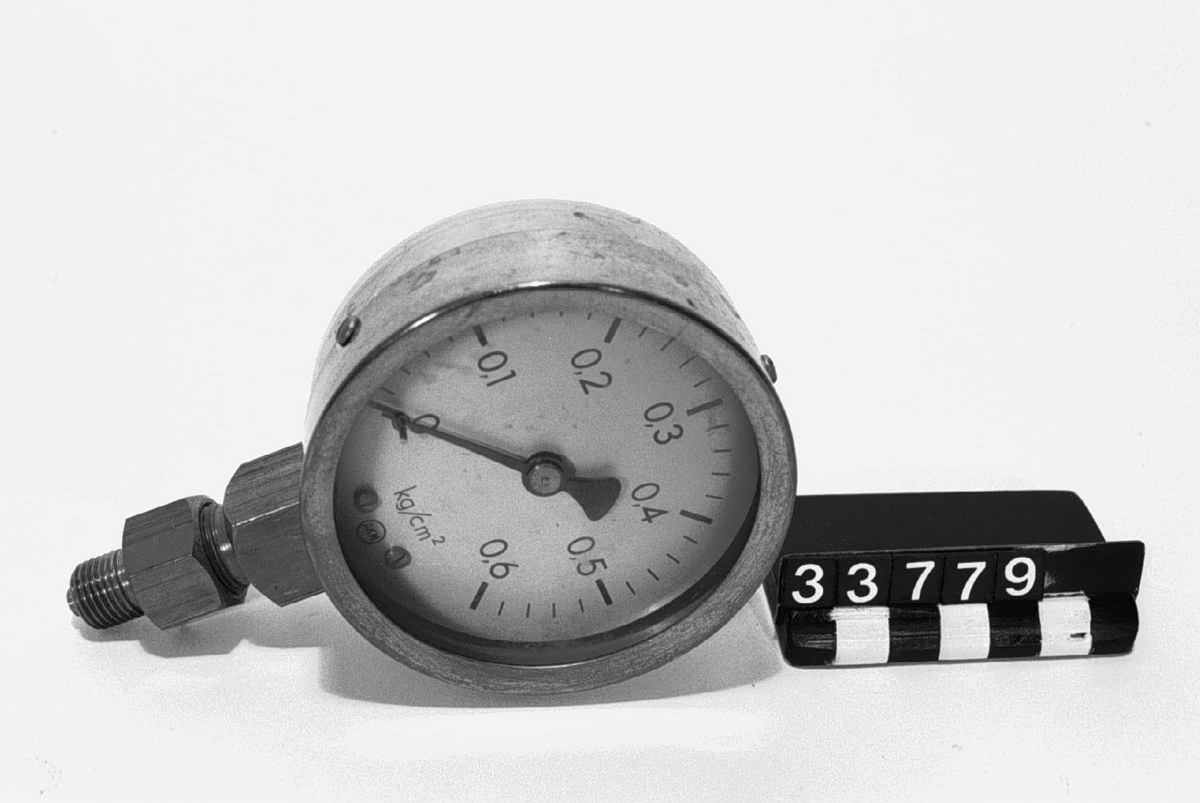 Manometer, monterad på förskruvning utan kran. Märkt: A.K.M. Graderad 0-0.6 kg/cm2.