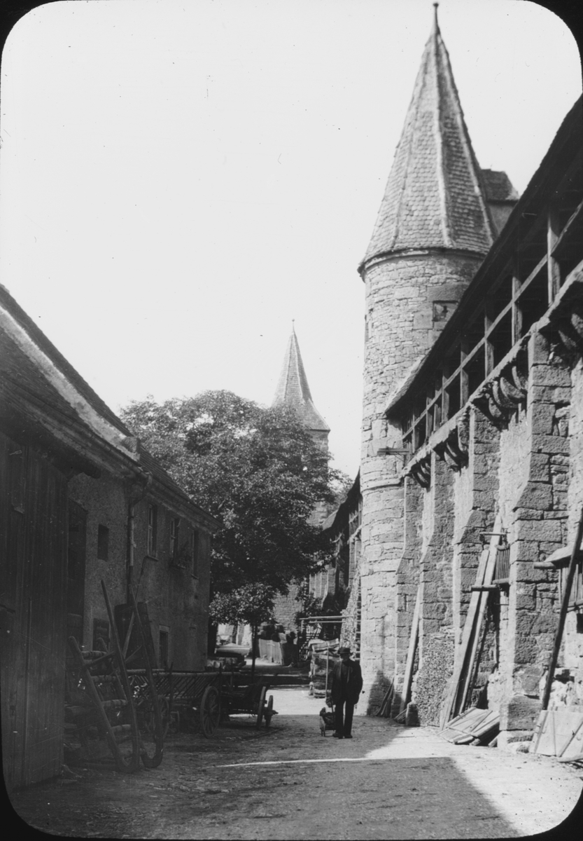 Skioptikonbild med motiv av stadsmuren med vaktgång, i Rothenburg ob der Tauber.
Bilden har förvarats i kartong märkt: Vårresan 1910. Rothenburg. XXX. Text på bild: "Schütt".