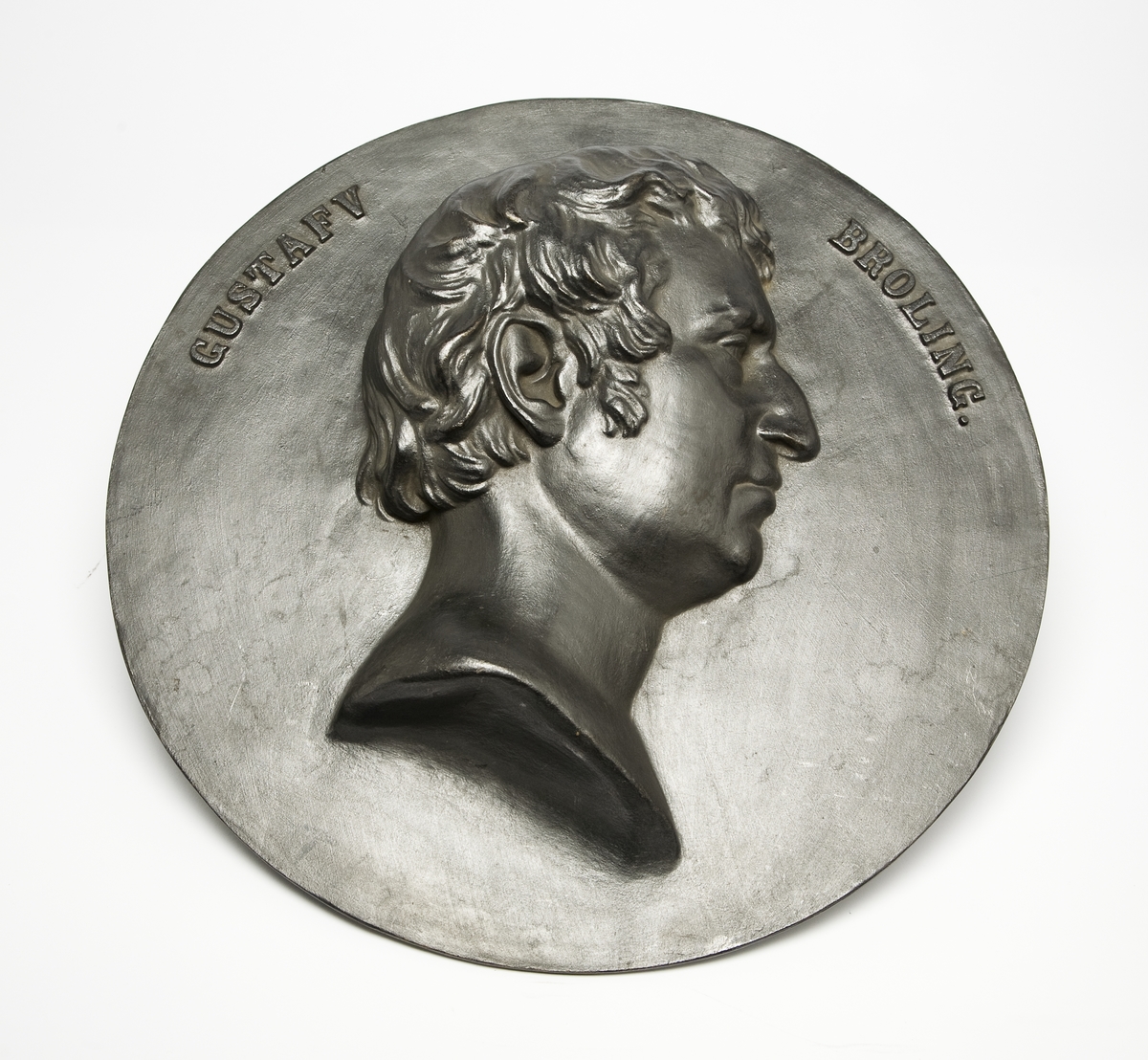 Medaljong av gjutjärn. Bergsrådet Gustaf Broling, höger profil, hög relief. "Gustaf Broling".