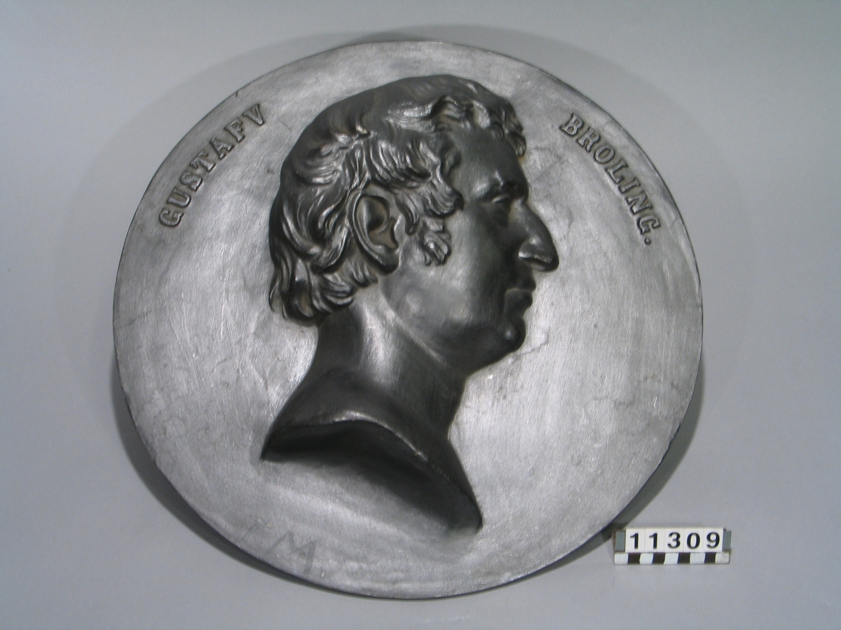 Medaljong av gjutjärn. Bergsrådet Gustaf Broling, höger profil, hög relief. "Gustaf Broling".