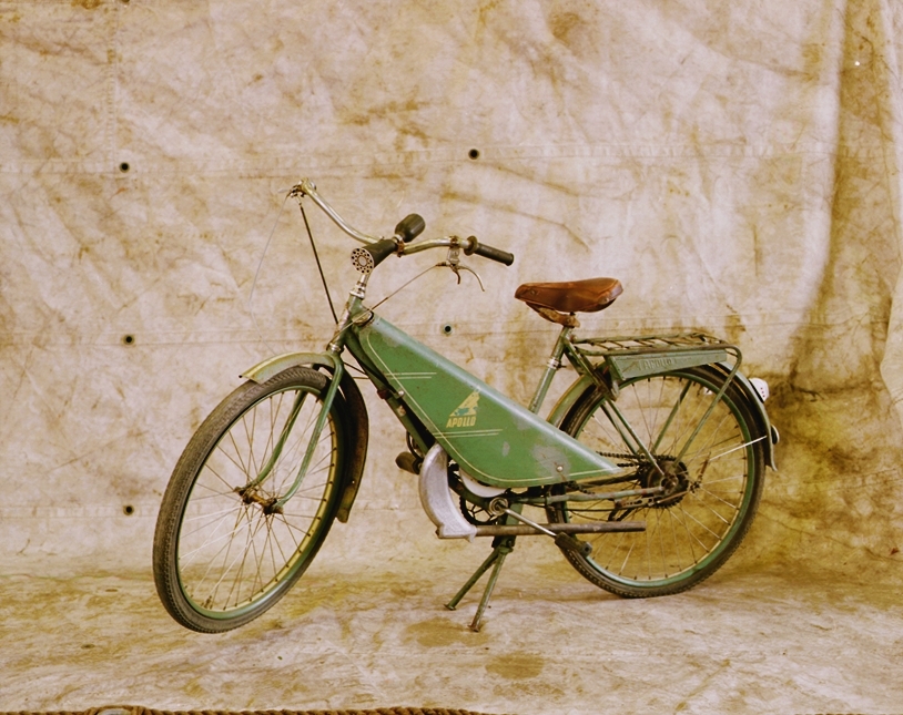 Engelsk Levis motor. Cykeln är tillverkad av Apollo, M. Berlin & Co som byggde ramen i Värnamo och monterade motorn under en skyddskåpa av pressad plåt. Motornummer 1064.  Encylindrig tvåtaktsmotor, cylindervolym 78 cc Effekt 2 hk En växel och kedjedrivning