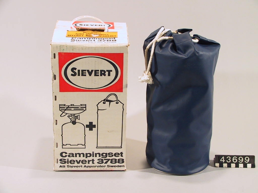 Campingset, kokapparat av plåt med gasflaska, i originallåda och en kraftig plastsäck.