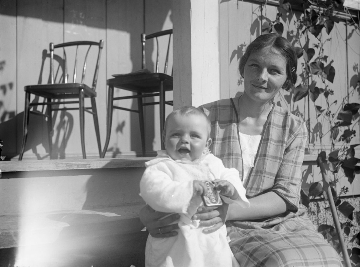 Kvinne og liten gutt på veranda.