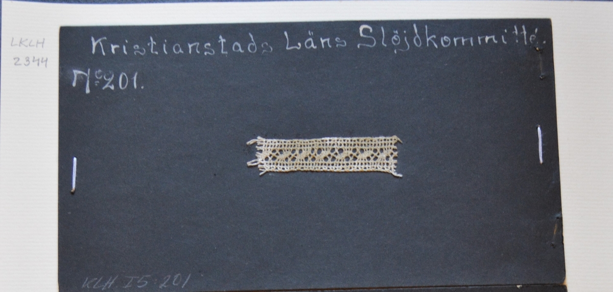 Kristianstads Läns Hemslöjdskommitté No 201.
Loppan.
Provet är monterat på svart kartong.