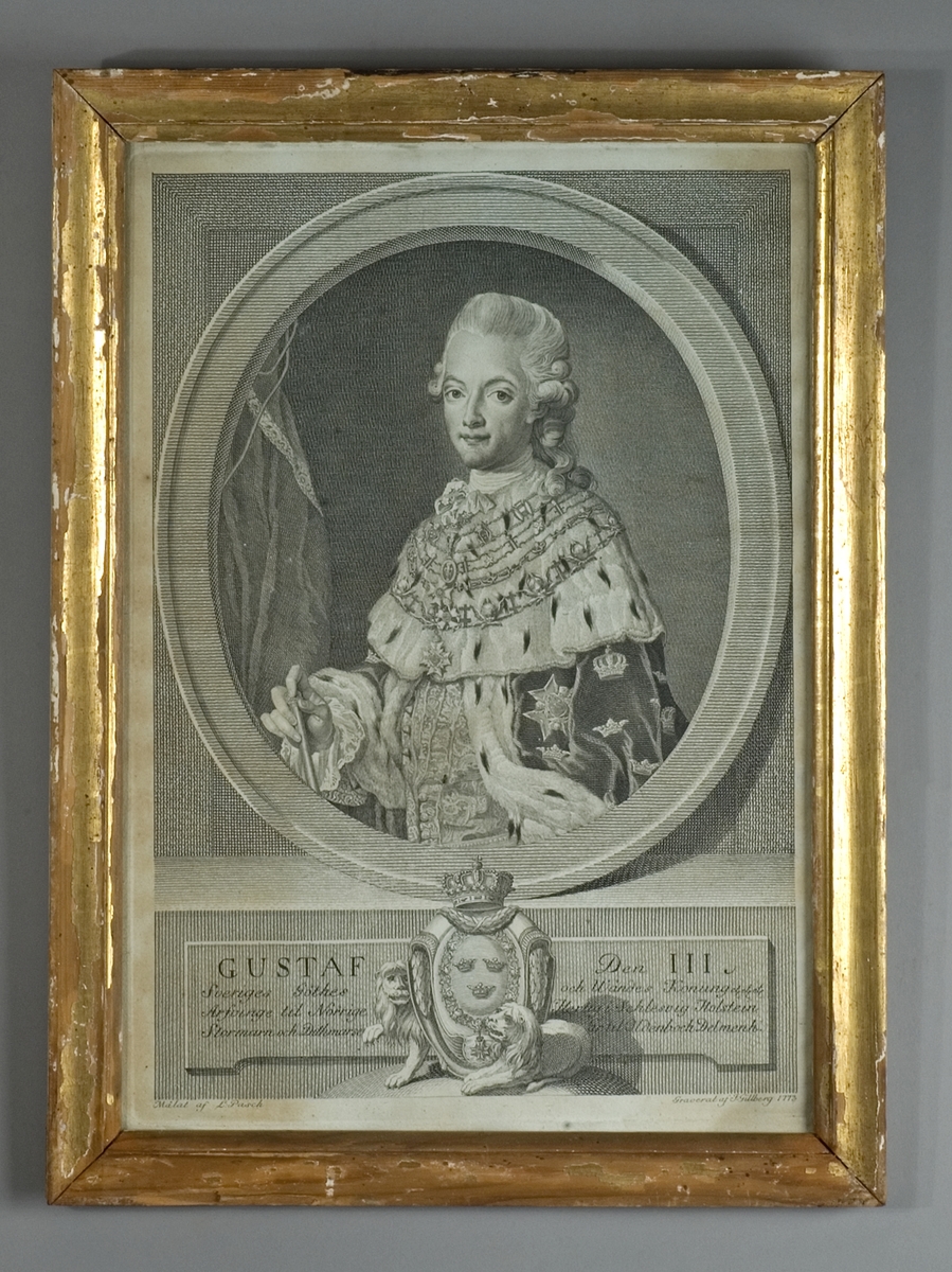Bröstbild föreställande Gustav III i oval inramning, klädd i hermelinsbrämad mantel med ordnar.  Nedtill riksvapnet med lagerfestoner och två liggande lejon,  omgivet av text på båda sidor.