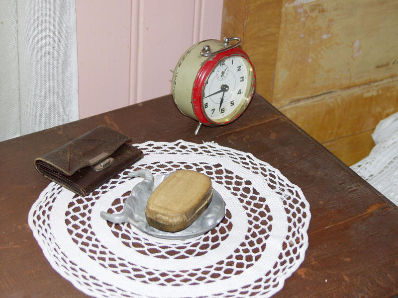 Bord med duk, klokke og ei lommebok