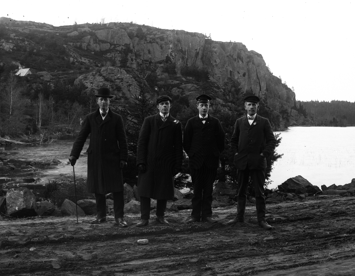 Fyra män fotograferade på en väg vid Skärsjön i Karl Gustav. I bakgrunden  ses Tjyvaklevsberget. Karl Sikén som tvåa från vänster. De övriga är inte identifierade.