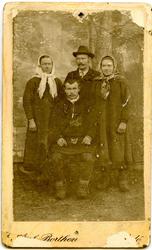 Gruppeportrett av ukjente personer. Mannen sittende i midten