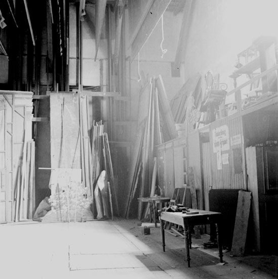 Örebro teater den 27 april 1937. En bild tagen ifrån teaterns scenhus bakom kulisserna. Här finns teaterns material som används till dekoren (teaterns scenbild), och en del annan rekvisita (tillbehör och förnödenheter) som behövs för teaterföreställningen. Genom att montera upp dekormaterialet på en rörlig vägg (platta) så får man en kuliss (en rörlig scenbild) som ensam eller tillsammans med andra kulisser skapar teaterns dekor.