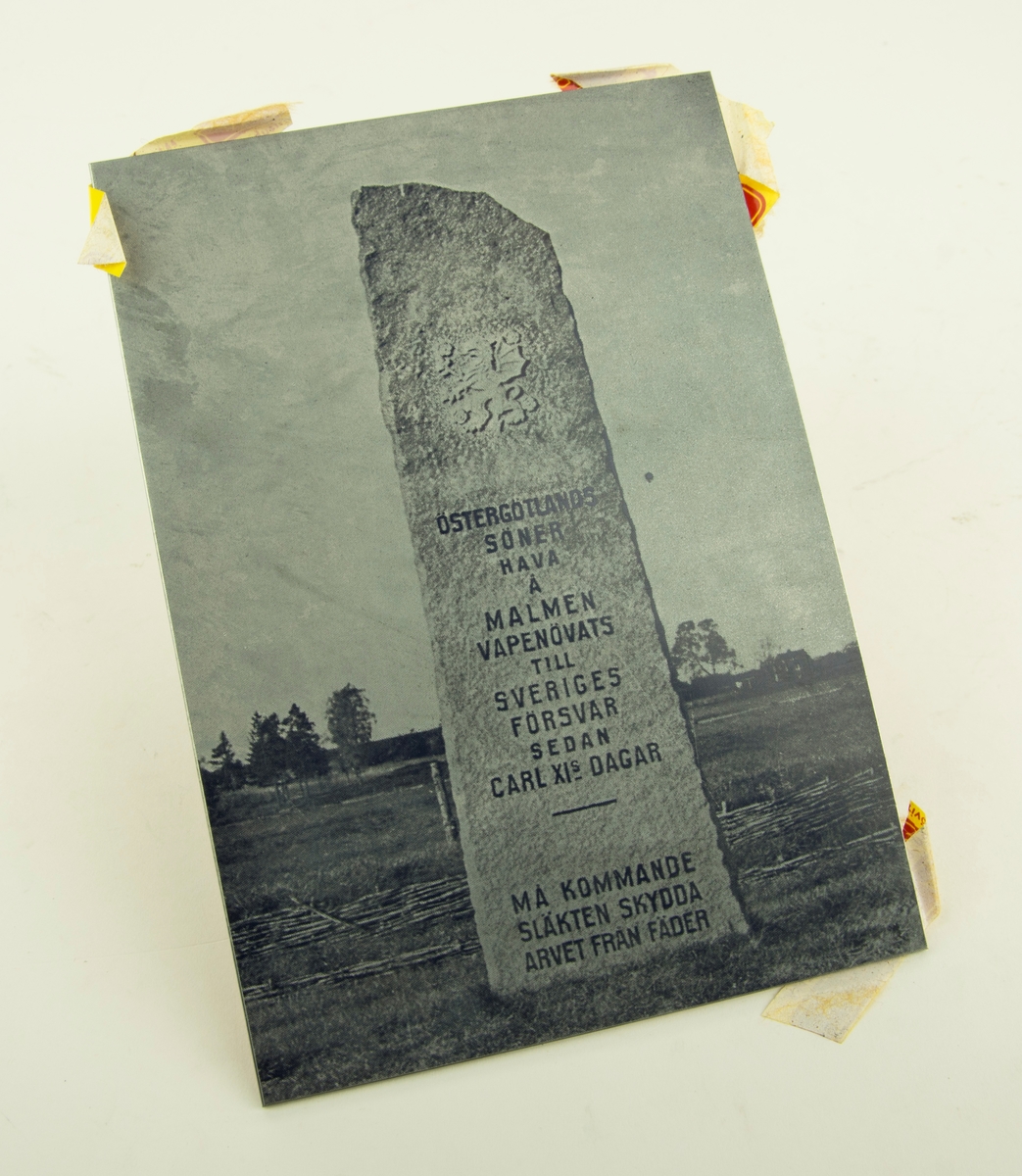 Kliché för tryckning av Svenska underbefälsförbundets 50-års jubileumsskrift. Klichén föreställer en sten med inskription på ett fält.