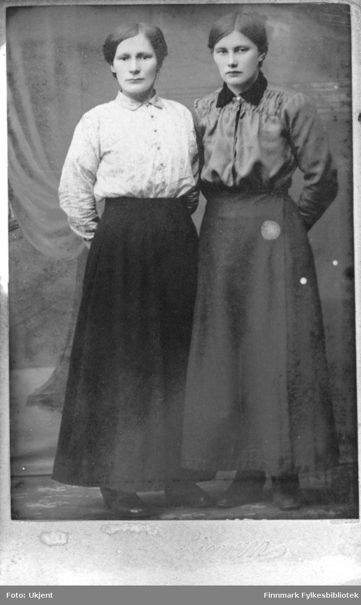 Søstrene Amundsen. Til venstre står Berit Amundsen og til høyre Inga Amundsen. Sammen arbeidet de i fiskeforedlingsindustrien. De  drev også et småbruk sammen med broren,  Anders Amundsen i Nuvsvåg. 