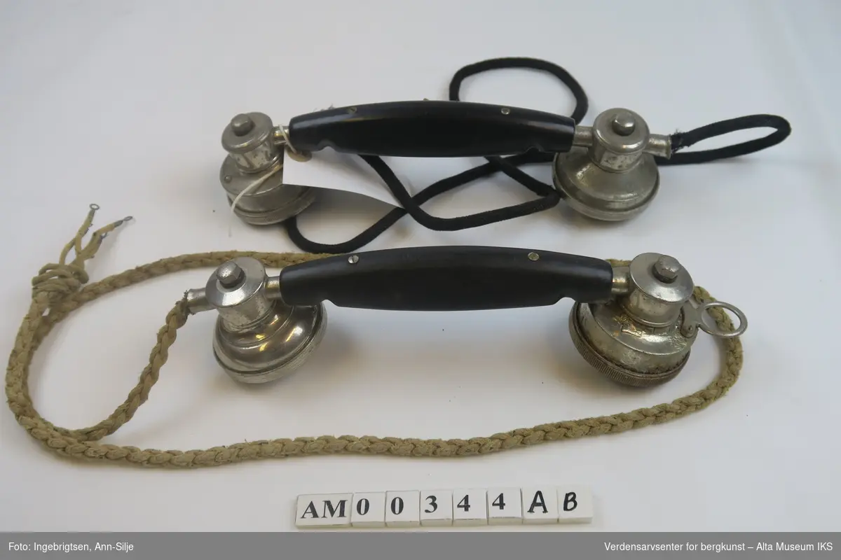 Telefonrør med avrevet ledning ledning. Blanke endestykker og sort håndtak.
