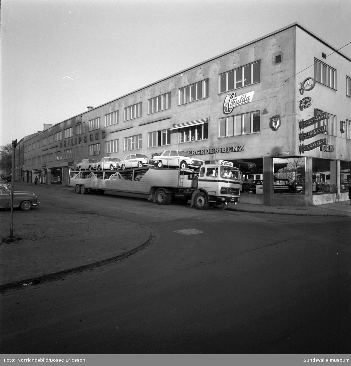 En stor trailer med bilar på Norra Järnvägsgatan utanför Philipssons bilfirma.