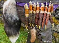 Knivsamler med hele ni kniver og revehale i beltet.  Fotogra