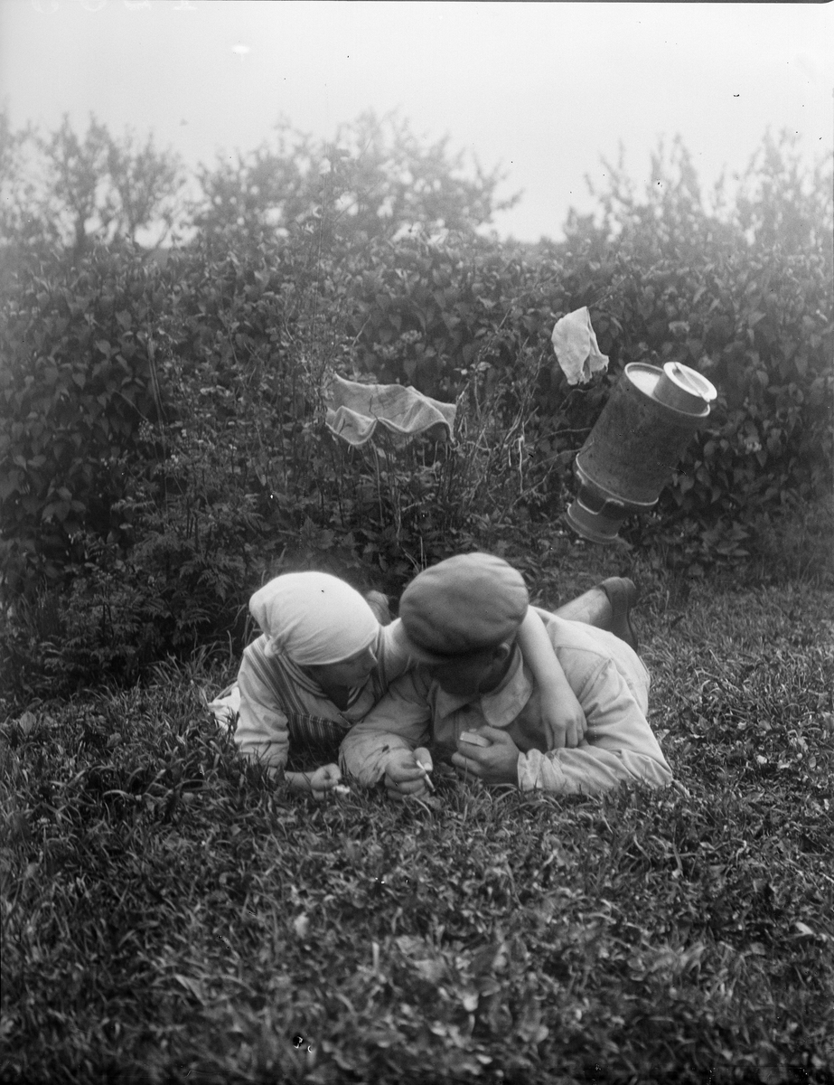 "Hilmer Salgren och Greta Anderson ligger i gröngräset", Sävasta, Altuna socken, Uppland 1919