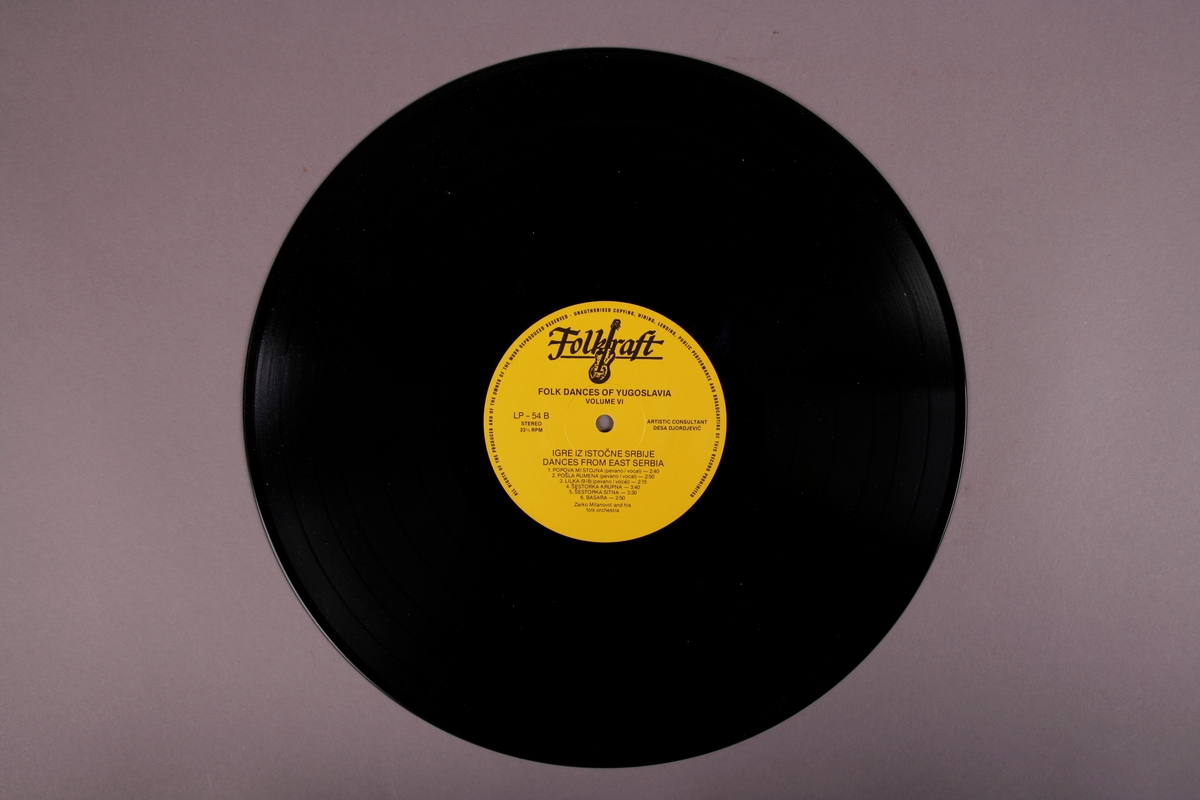 Grammofonplate i svart vinyl, papirlomme med påsatt tekstark, og et hefte med tekniske tegninger om dansetrinn.