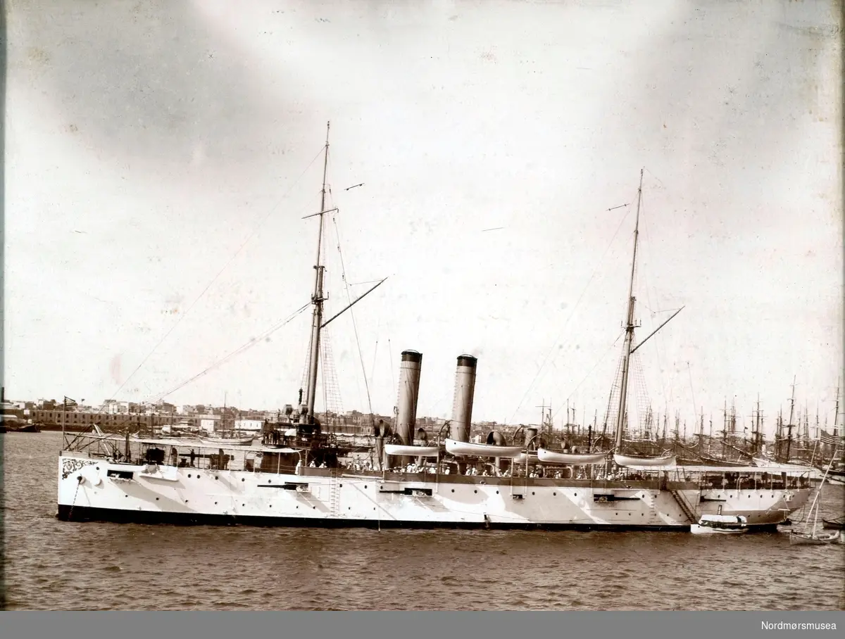 Fartøyet på bildet er en amerikansk krysser av Denver-klassen. Stevndekoren tyder på at dette er USS Tacoma C-18, bygget i 1904. Ref; http://www.navsource.org/archives/04/c18/c18.htm (Info: Espen Arnestad - 19.10.2016). dampskip   Fra Nordmøre museums fotosamlinger.