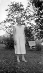 Portrett av en kvinne i en hage. Kan det være tatt i Eidsvåg