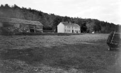 Foto av et eldre gårdsbruk. Usikkert hvorfra bildet er tatt,