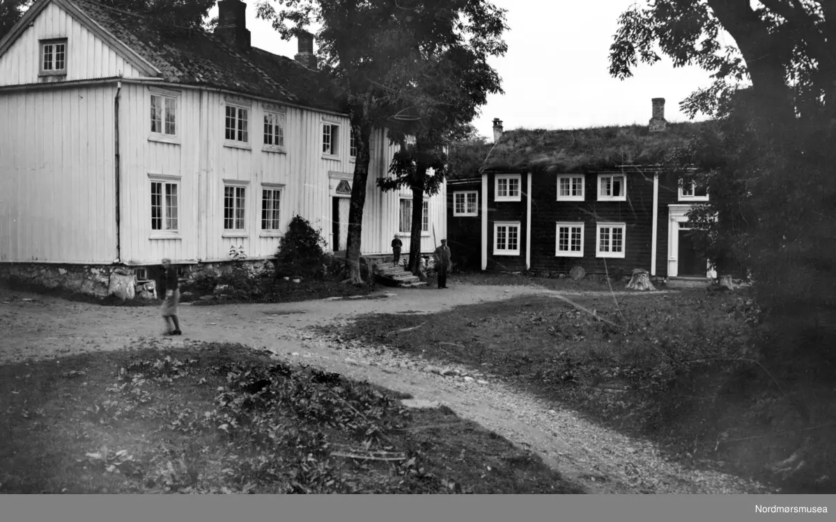 Foto fra Gjemnes gård i Gjemnes kommune, hvor vi ser to gårdshus med ...