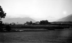 Jordbruksområde med beitemark, hersjer og bebyggelse, med fj