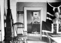 Interiørfoto fra en stue,hvor vi ser to store norske flagg s