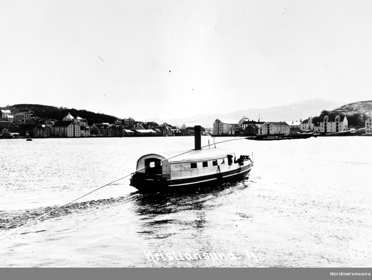 Foto sannsynligvis av Sundbåten Fram ute i havnebassenget i Kristiansund. Båten ble bygget i 1878 ved Trondheims Mekaniske Verksted og var 11,7 meter lang, 2,5 meter bred og veide 15,38 bruttotonn.. Båten ble senere sertifisert for 45 passasjerer og ble satt i drift 17. juni 1878. Ved utbruddet av andre verdenskrig ble Fram senket under bombingen 28. april til 1. mai 1940. Båten ble hevet 8. mai og satt på slipp ved Sterkoder, for så å bli reparert der i 1941. Båten opphørte i drift da formannskapet vedtok den 21. august 1958 å overdra Fram vederlagsfritt til Havnevesenet som arbeidsbåt. Fra Nordmøre Museums fotosamlinger.
