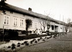 En gruppe mennesker foran et bolighus. Fra Nordmøre museums 