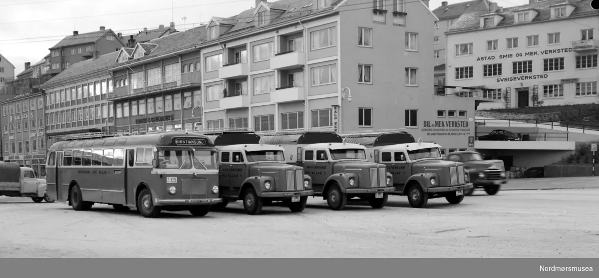 Torkil Øyen 2011: Bilene på bildet er
tre stk Scania-Vabis L75-54 1959 modeller, levert til KFB den 01.03.1960. De ble da satt inn på den nystartede person/godsruta til Åndalsnes. Regnr var T-6102, T-6103 og T-6104, den siste er restaurert og står på Stortua, det gjør også en av de to andre da denne ble ombygd til kranvogn/bergingsbil i 1971/72 og omreg til UX 12679 den 25.03.72.

Hengeren på bildet er en Maur 60A 1960 mod med regnr T-6108 som kunne være kjekk å ha ved store godsmengder..

Fra Nordmøre Museums fotosamlinger.



