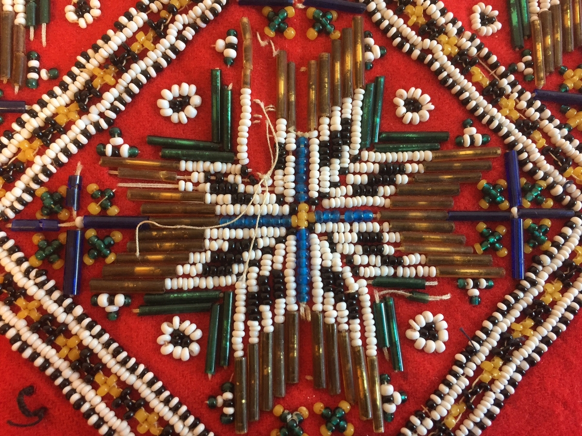 Lue, bryststykke/bringeduk og belte (C) til hardangerbunad, forkle (E) og skjorte (D) med hardangersømdetaljer.