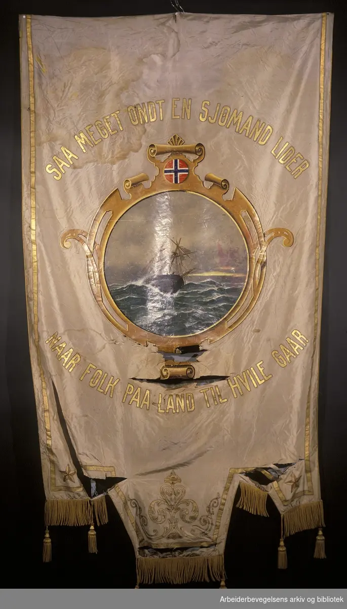 Norsk sjømannsforbund Oslo avdeling.Stiftet 14.februar 1908..Bakside..Fanetekst: Saa meget ondt en sjømand lider Naar folk på land til hvile gaar