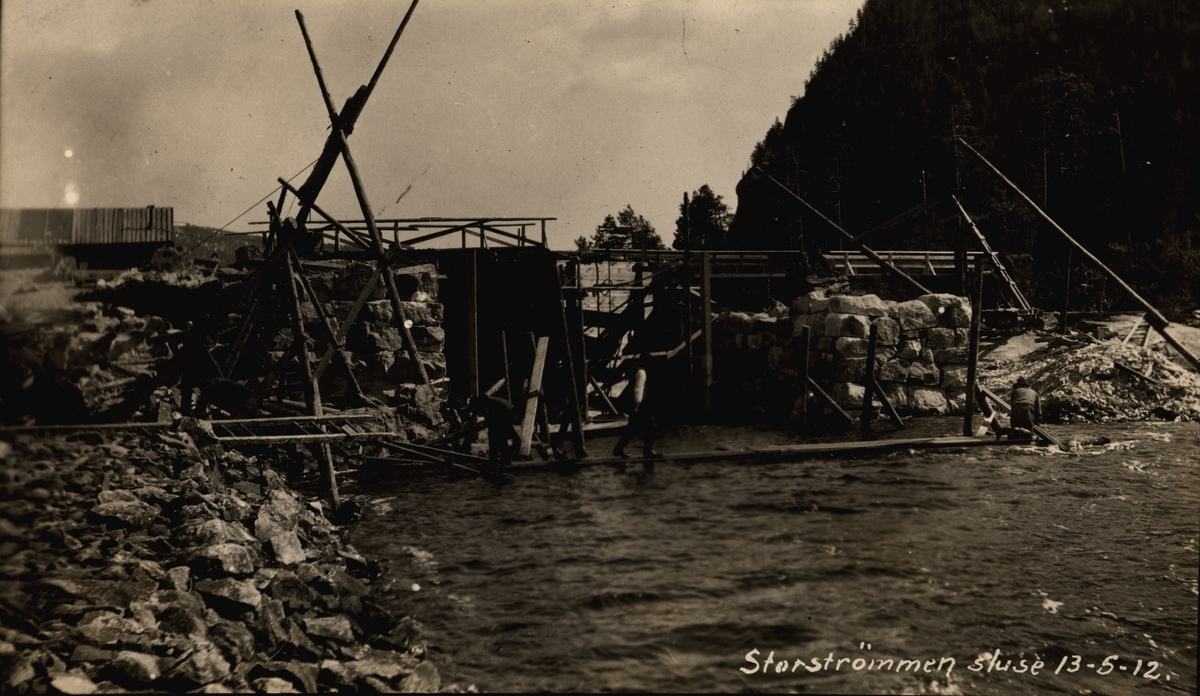 Storstrømmen sluse. Mudring ved Øvre fangdam. Menn / arbeidere jobber med en trekonstruksjon. Vann og elv. (Arkiv: Kanalvesenet/Vassdragsvesenet Uba-2-54)