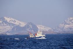 Fiskebåt på havet, Lofoten, med Lofotveggen i bakgrunnen